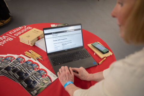 Business Wales Skills advisor using a laptop to present the flexible skills program